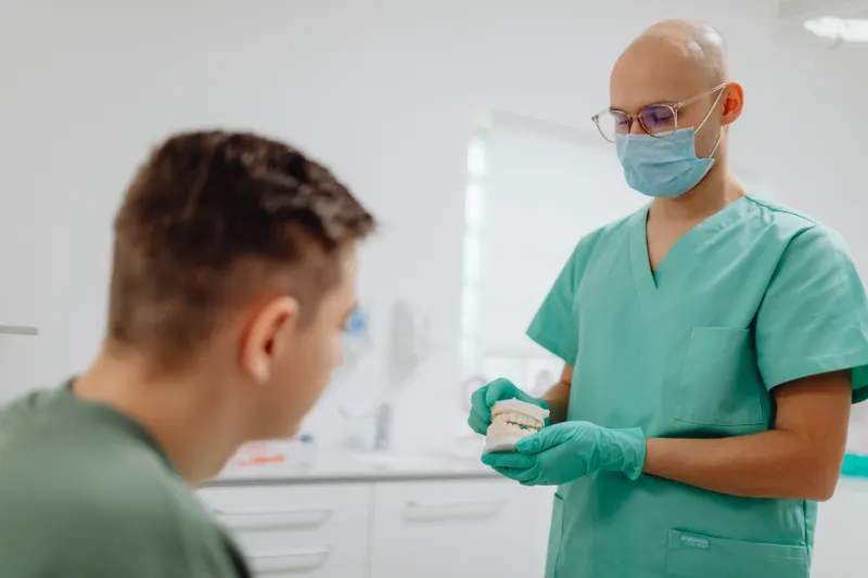 A dentist sits and talks with a patient in the dental chair before starting